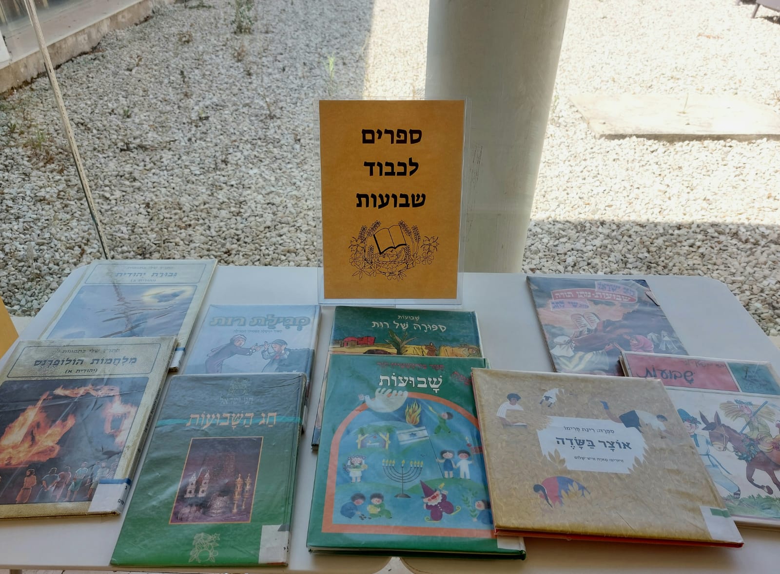 שולחן בספרייה עם ספרים בנושא שבועות